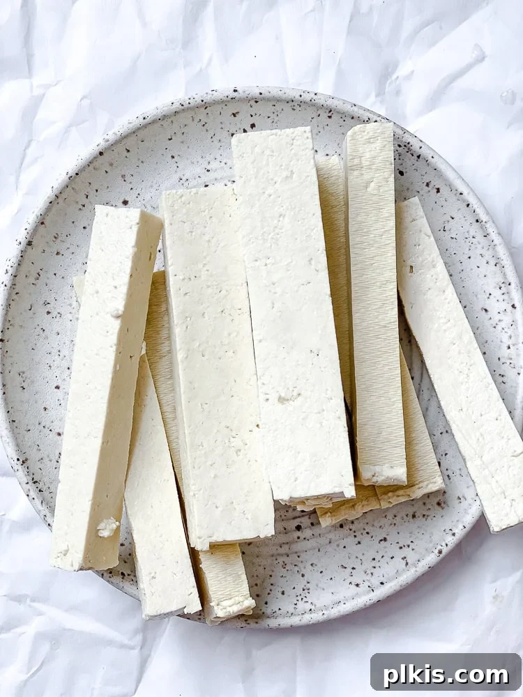 Crispy Vegan Fish Fingers 4 Process shot showing slices of pressed tofu on a plate, ready for marinating.