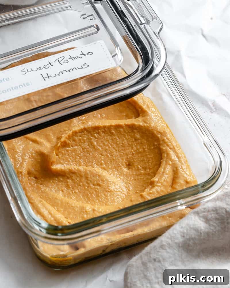 Golden Sweet Potato Hummus 11 Sweet potato hummus stored in a clear glass airtight container in the refrigerator.
