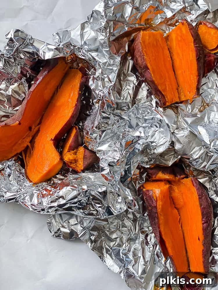 Golden Sweet Potato Hummus 6 Three halved roasted sweet potatoes, cooling on a plate after being unwrapped.