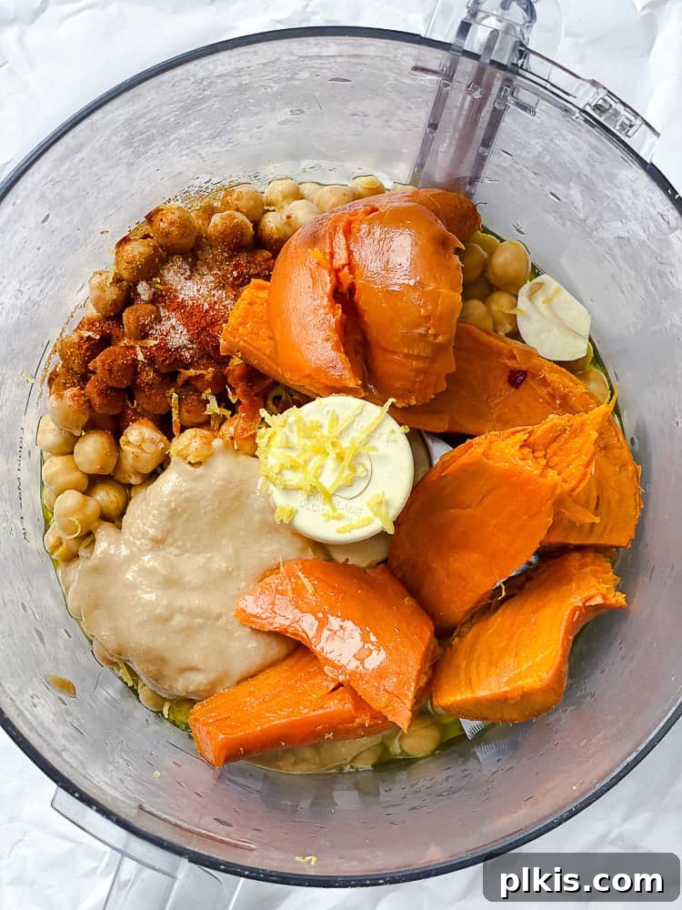 Golden Sweet Potato Hummus 7 All the hummus ingredients, including chickpeas, tahini, lemon, spices, and olive oil, in a food processor bowl before blending.