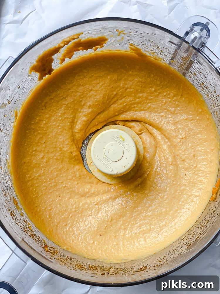 Golden Sweet Potato Hummus 9 Smooth and creamy sweet potato hummus fully blended in a food processor bowl.
