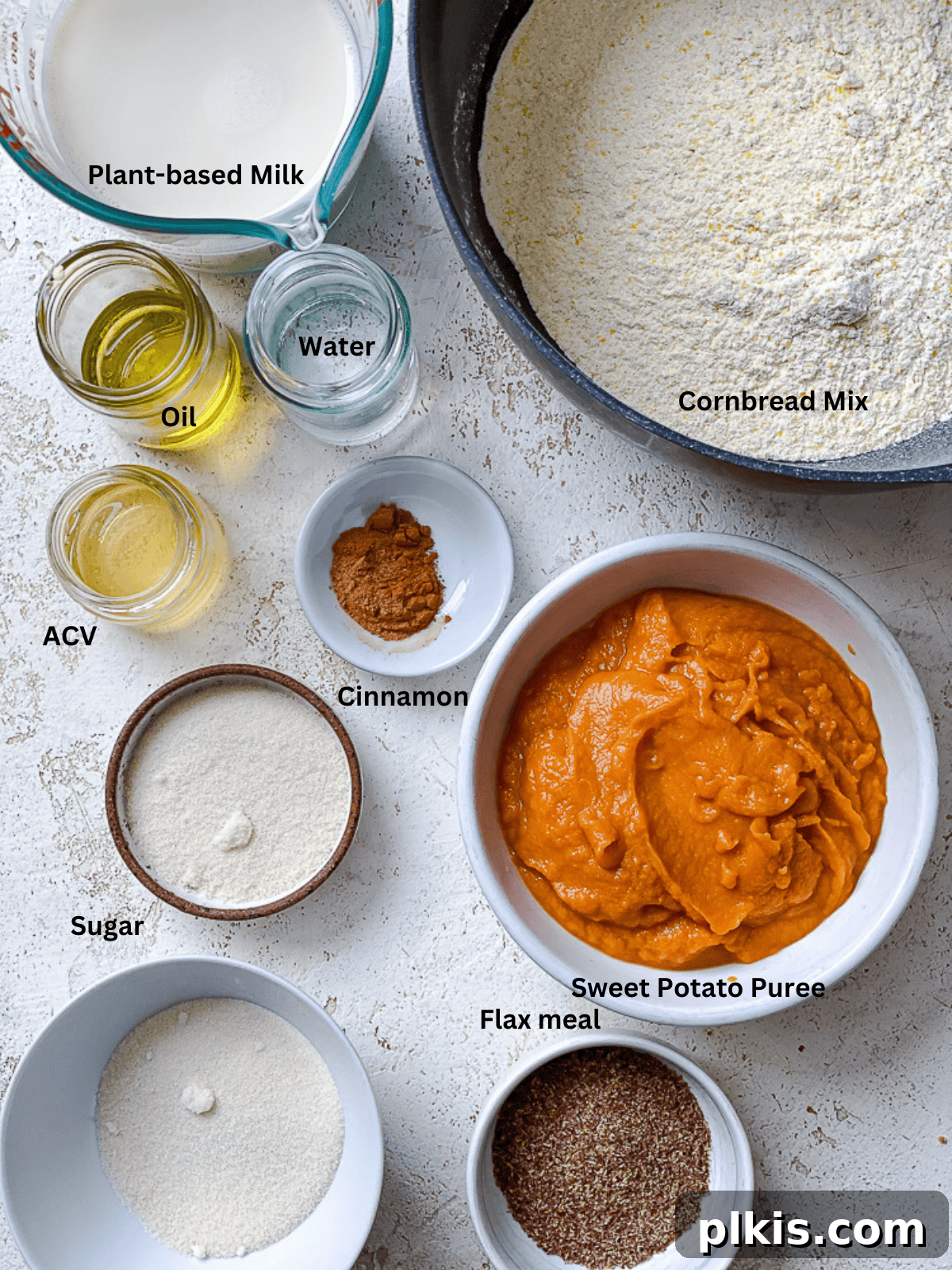 Spiced Sweet Potato Cornbread 3 Various sweet potato cornbread ingredients, including plant milk, flax meal, sweet potato puree, and spices, measured out in bowls.