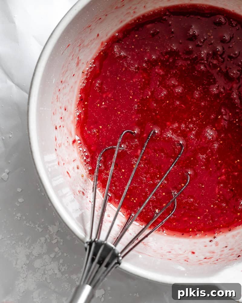 Effortless Strawberry Glaze for All Your Sweet Treats 2 A process shot showing ingredients for strawberry glaze being whisked together in a bowl, highlighting the creamy texture.