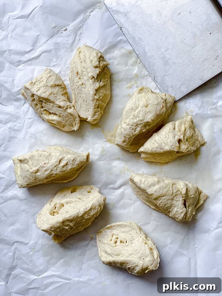 Fluffy Vegan Naan 12 Vegan naan dough precisely cut into eight small, equal pieces, ready for shaping.