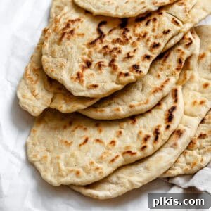 Fluffy Vegan Naan 16 A pile of vegan naan, golden and fluffy, ready to be enjoyed.