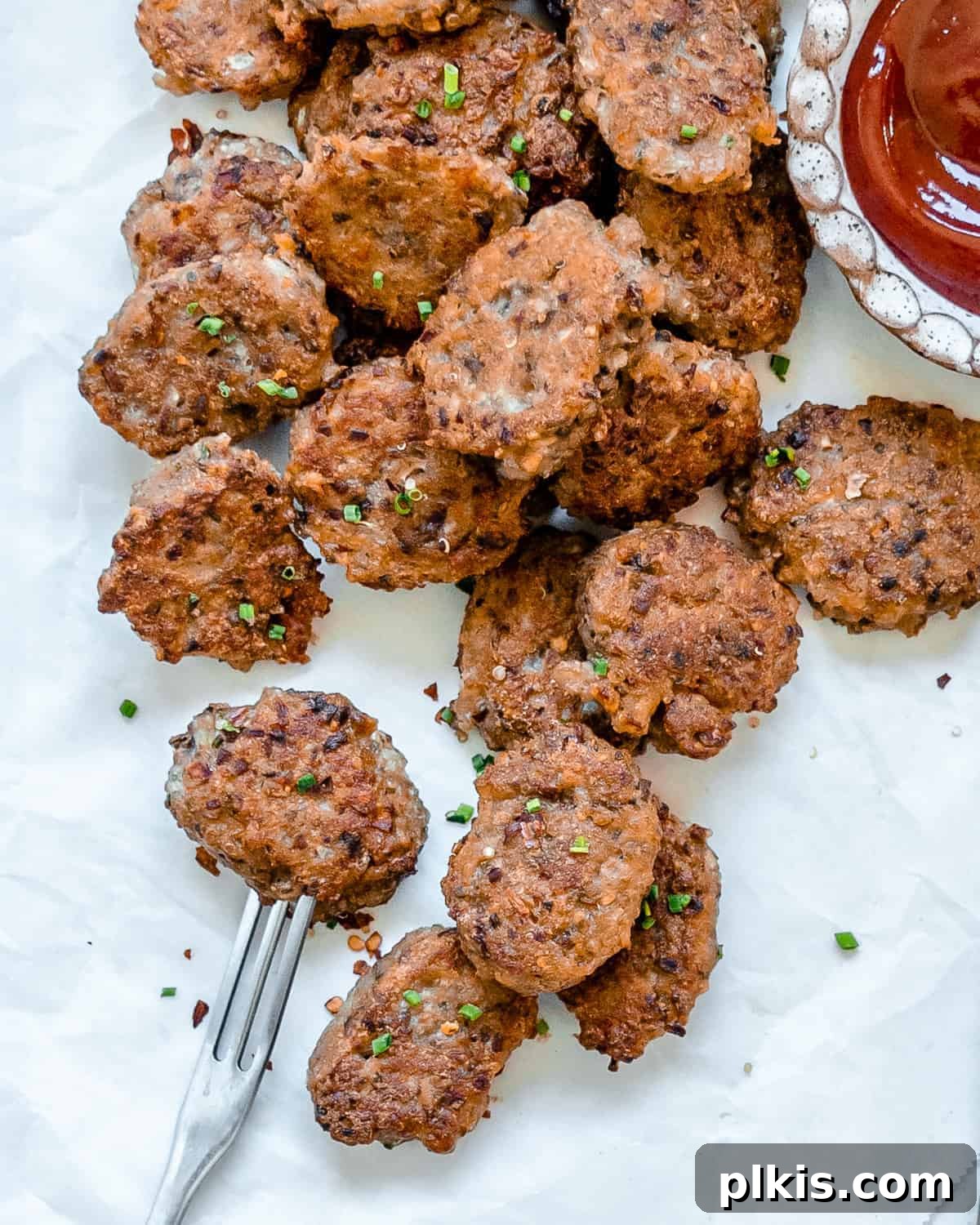 Crispy Quinoa Bites 2 completed Quinoa Tater Tots on a white surface with a fork and sauce on the side
