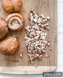 Crispy Quinoa Bites 6 finely diced mushrooms on a brown cutting board with whole mushrooms on the side