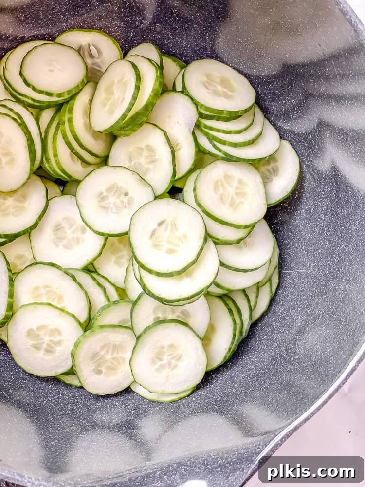 Crisp Cucumber and Pepper Medley 5 Thinly sliced cucumbers, prepared with care, ready to be mixed into the salad.