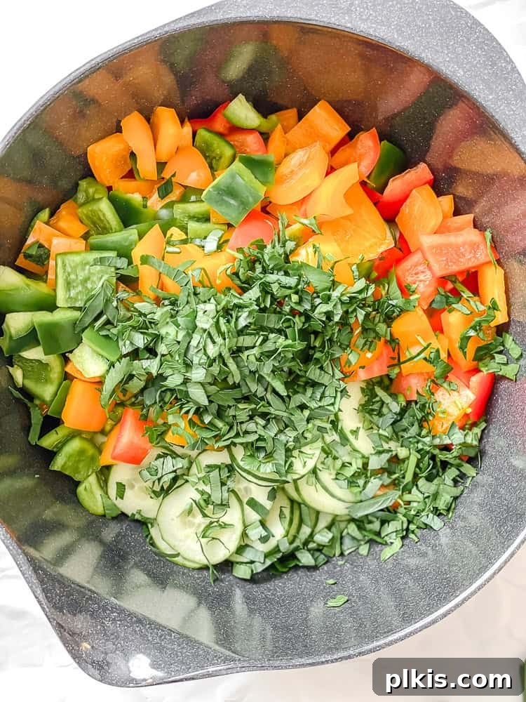 Crisp Cucumber and Pepper Medley 6 All prepared ingredients for the salad are combined in a large bowl, showing a medley of colors.