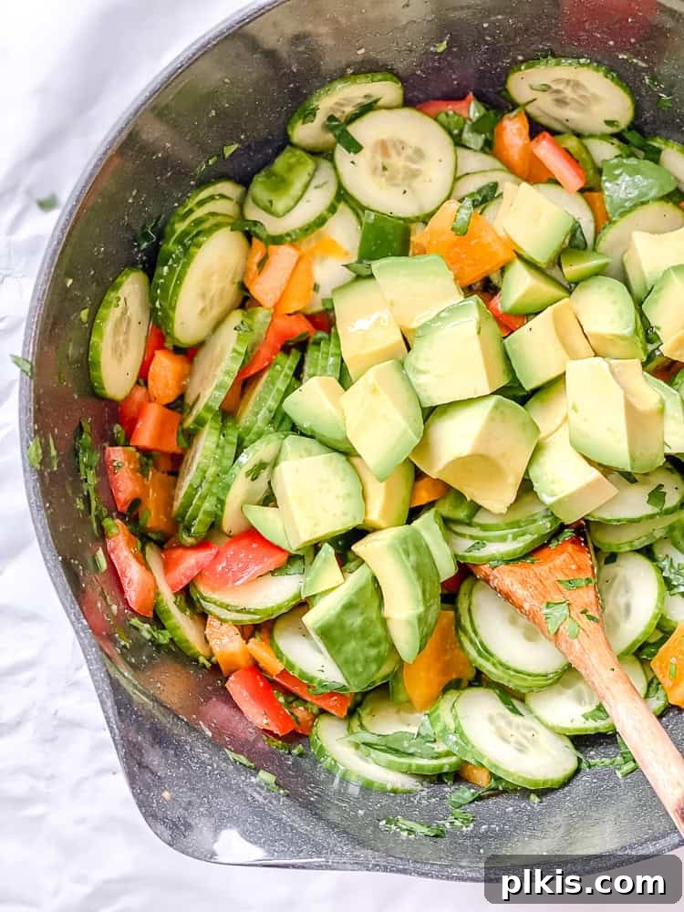 Crisp Cucumber and Pepper Medley 7 A close-up shot of the salad ingredients being mixed gently in a bowl to combine flavors.