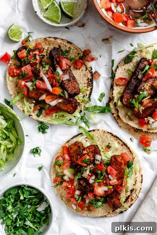 Speedy Tempeh Tacos 2 Completed Easy Tempeh Tacos on a white surface, garnished with fresh cilantro and lime