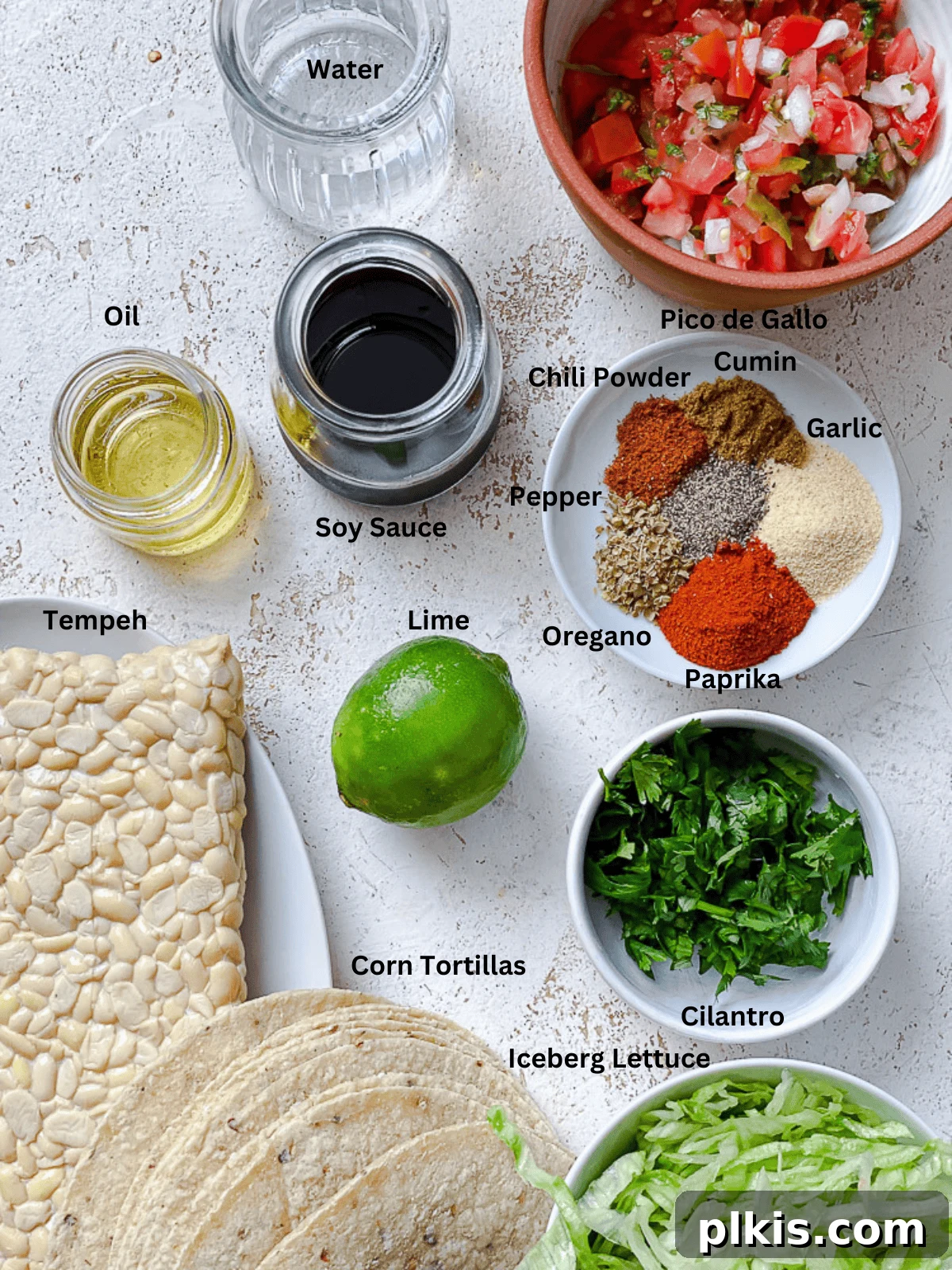 Speedy Tempeh Tacos 3 Ingredients for Easy Tempeh Tacos measured out on a white surface, showcasing fresh produce and spices