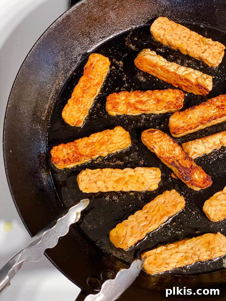 Speedy Tempeh Tacos 5 Process shot showing marinated tempeh cooking in a pan until golden brown