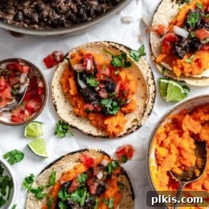 Several completed Sweet Potato and Black Bean Tacos on a white surface, ready to be served.