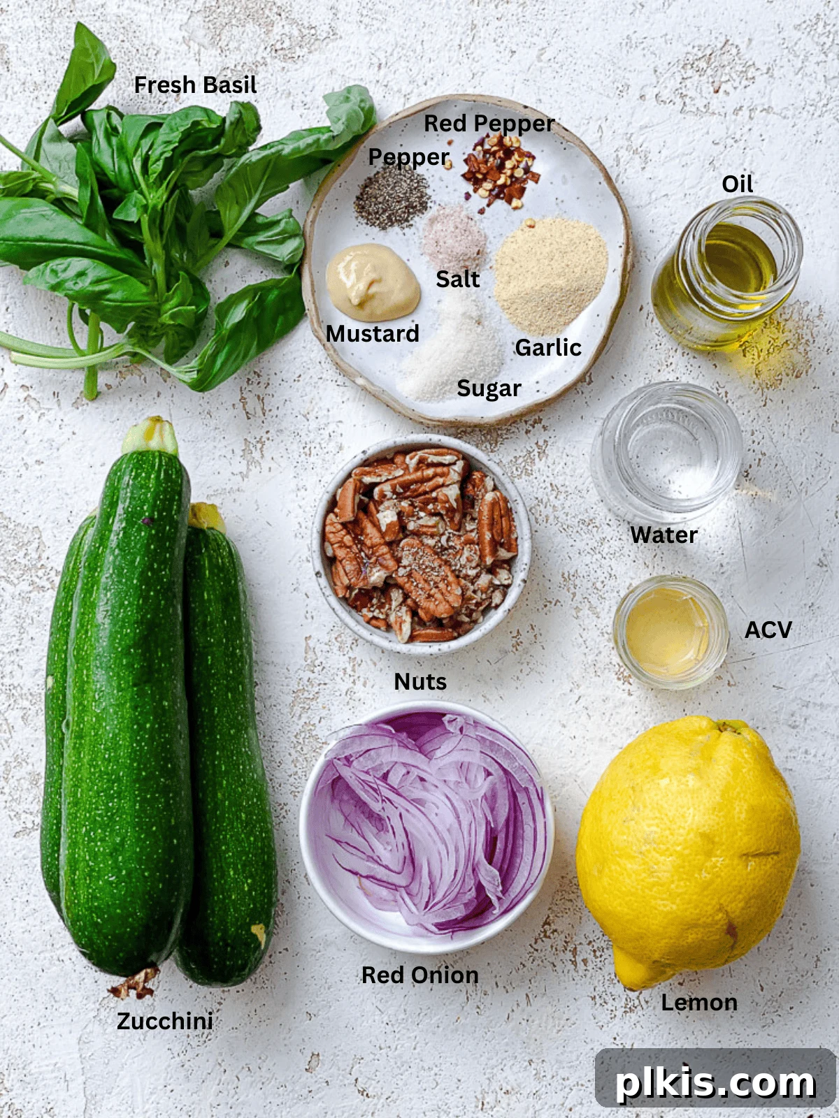 Zesty Zucchini Salad 3 Fresh ingredients for making zucchini salad, including whole zucchini, red onion, basil, and dressing components laid out with labels.