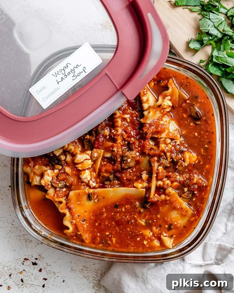 Tuscan Vegan Lasagna Soup 15 Leftover vegan lasagna soup stored neatly in a transparent airtight container, ready for refrigeration.