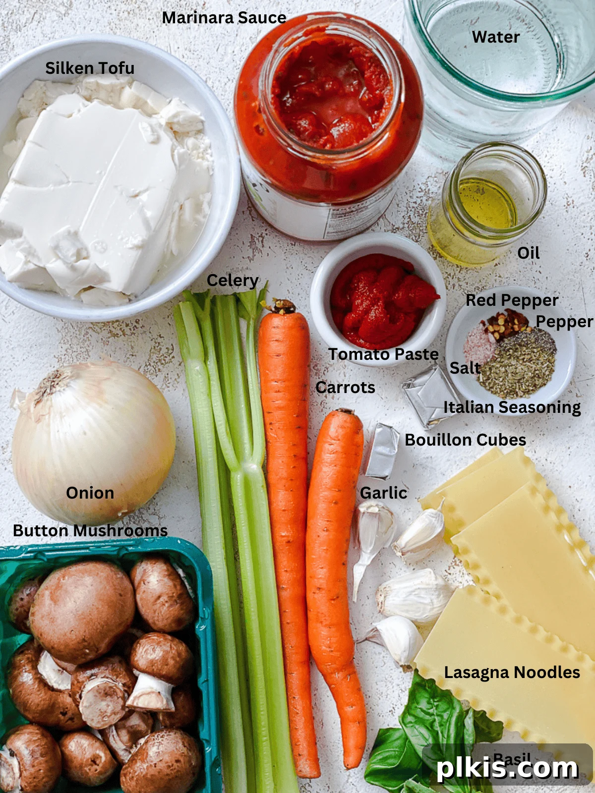 Tuscan Vegan Lasagna Soup 3 A flat lay of fresh ingredients arranged for vegan lasagna soup preparation, including carrots, celery, onions, garlic, mushrooms, tomato paste, and a package of silken tofu.