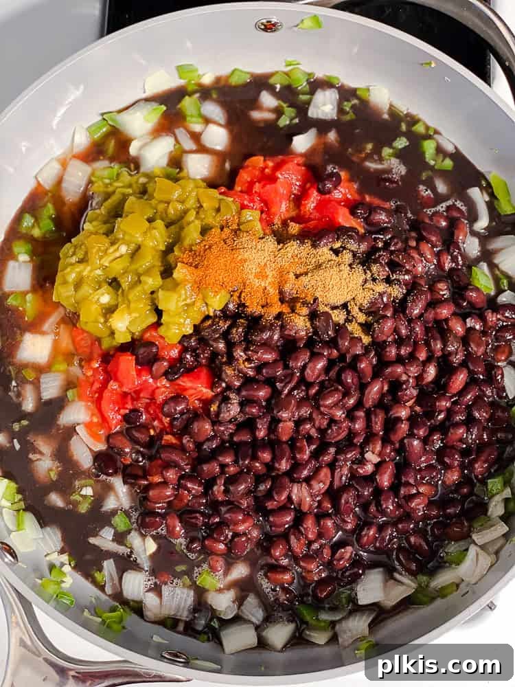 process shot showing all chili ingredients simmering together in a pan.