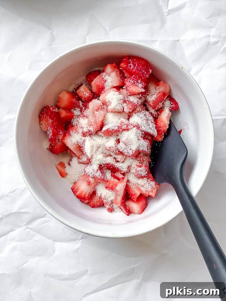 Fluffy Strawberry Pancakes 4 process shot showing mixing strawberries and sugar together in bowl