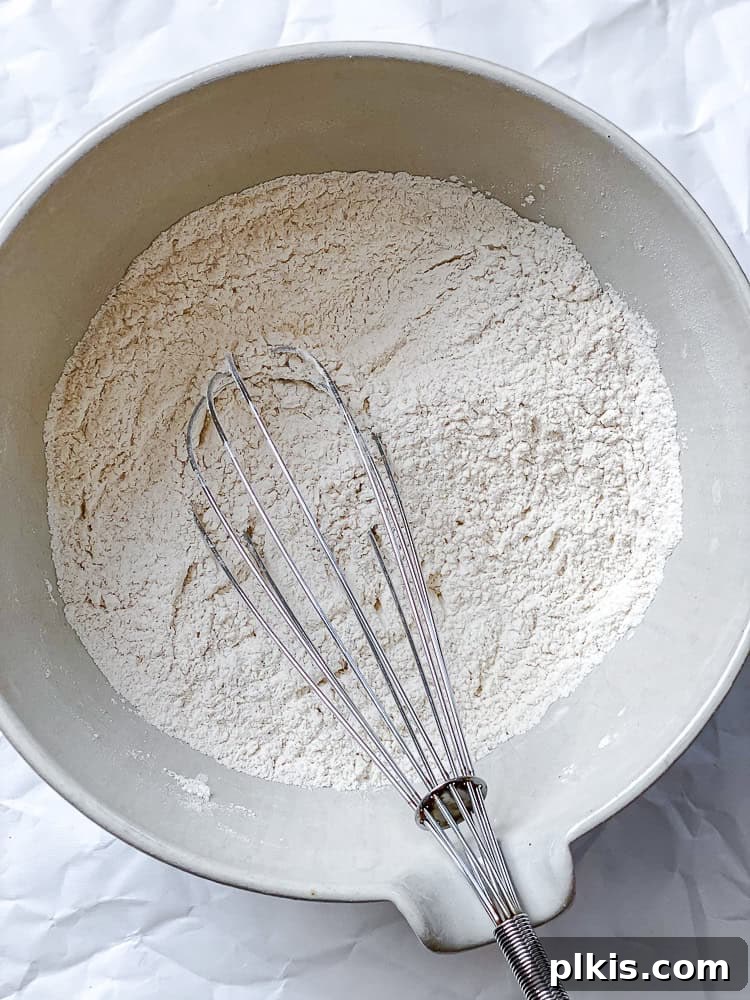 Fluffy Strawberry Pancakes 6 process shot showing mixing ingredients together in bowl with whisk