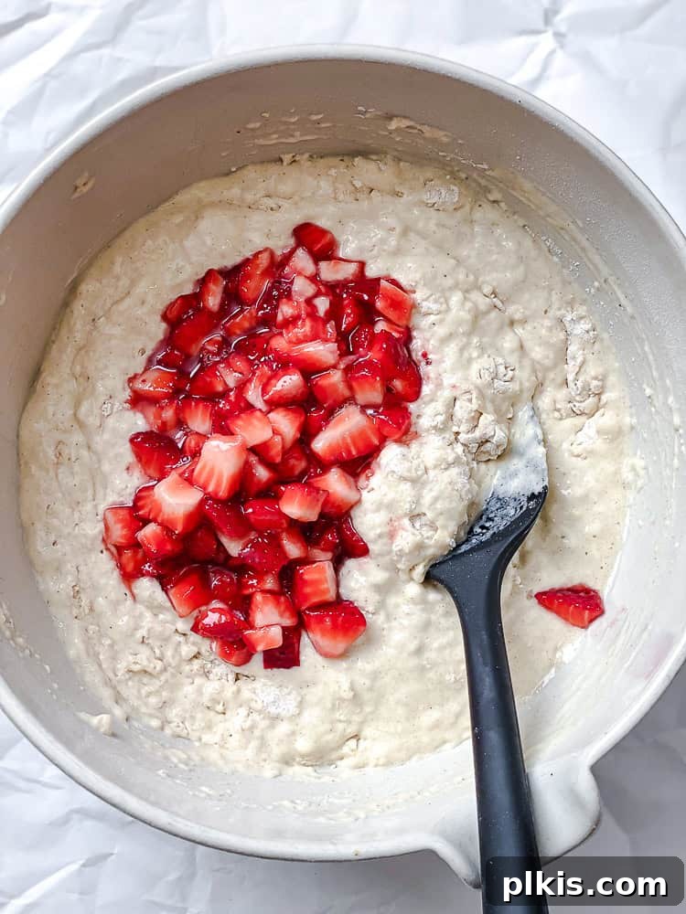 Fluffy Strawberry Pancakes 7 process shot showing strawberries added to batter in bowl