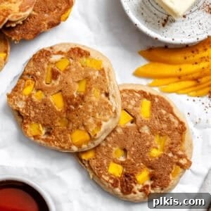 Completed fluffy mango pancakes on a white surface, ideal for breakfast or brunch.