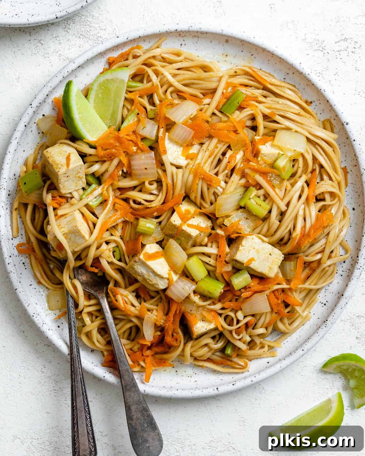 completed Pancit Bihon [Filipino Rice Noodles] plated on a plate against a white background