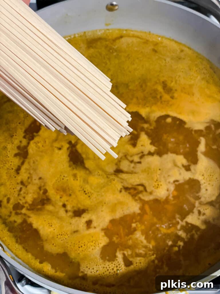 Filipino Pancit Bihon Noodles 13 process shot of adding noodles to pan