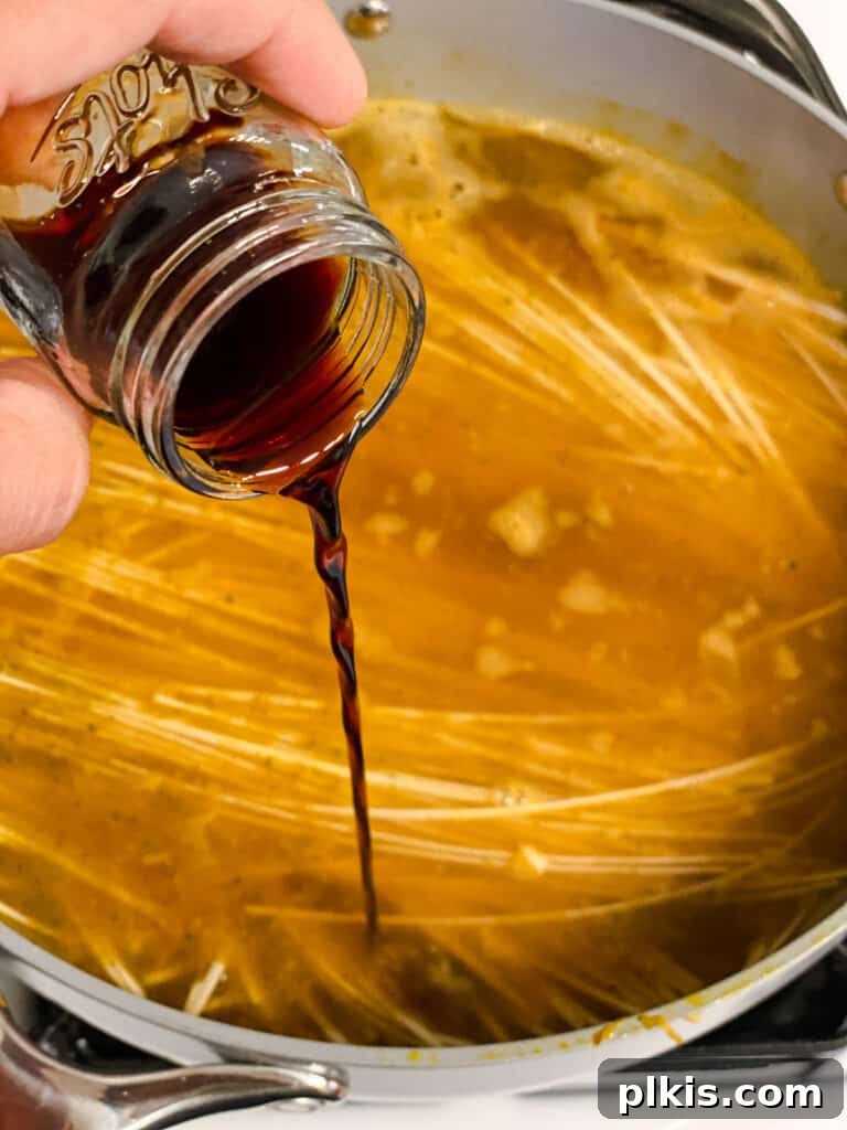 Filipino Pancit Bihon Noodles 14 process shot of adding soy sauce to pan
