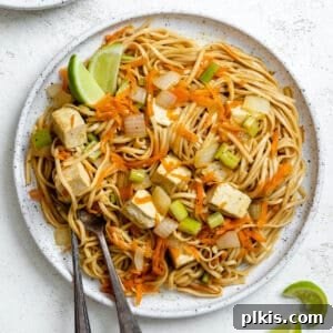 completed Pancit Bihon [Filipino Rice Noodles] plated on a plate against a white background