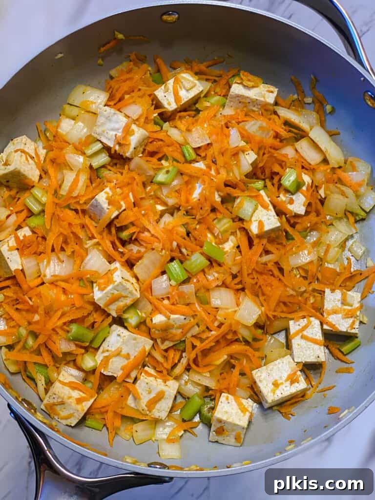 Filipino Pancit Bihon Noodles 10 process shot of veggies and tofu cooking in a pan