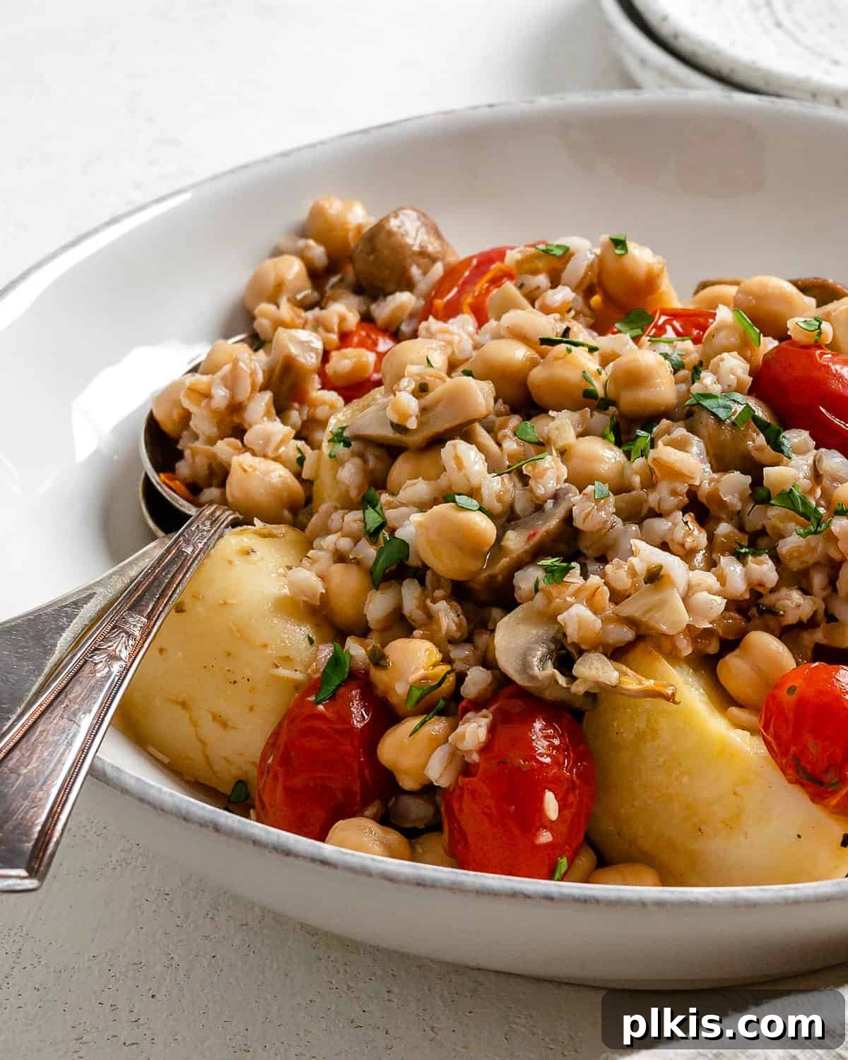 Completed Easy Farro Recipe with Roasted Vegetables plated on a white plate, garnished with fresh parsley