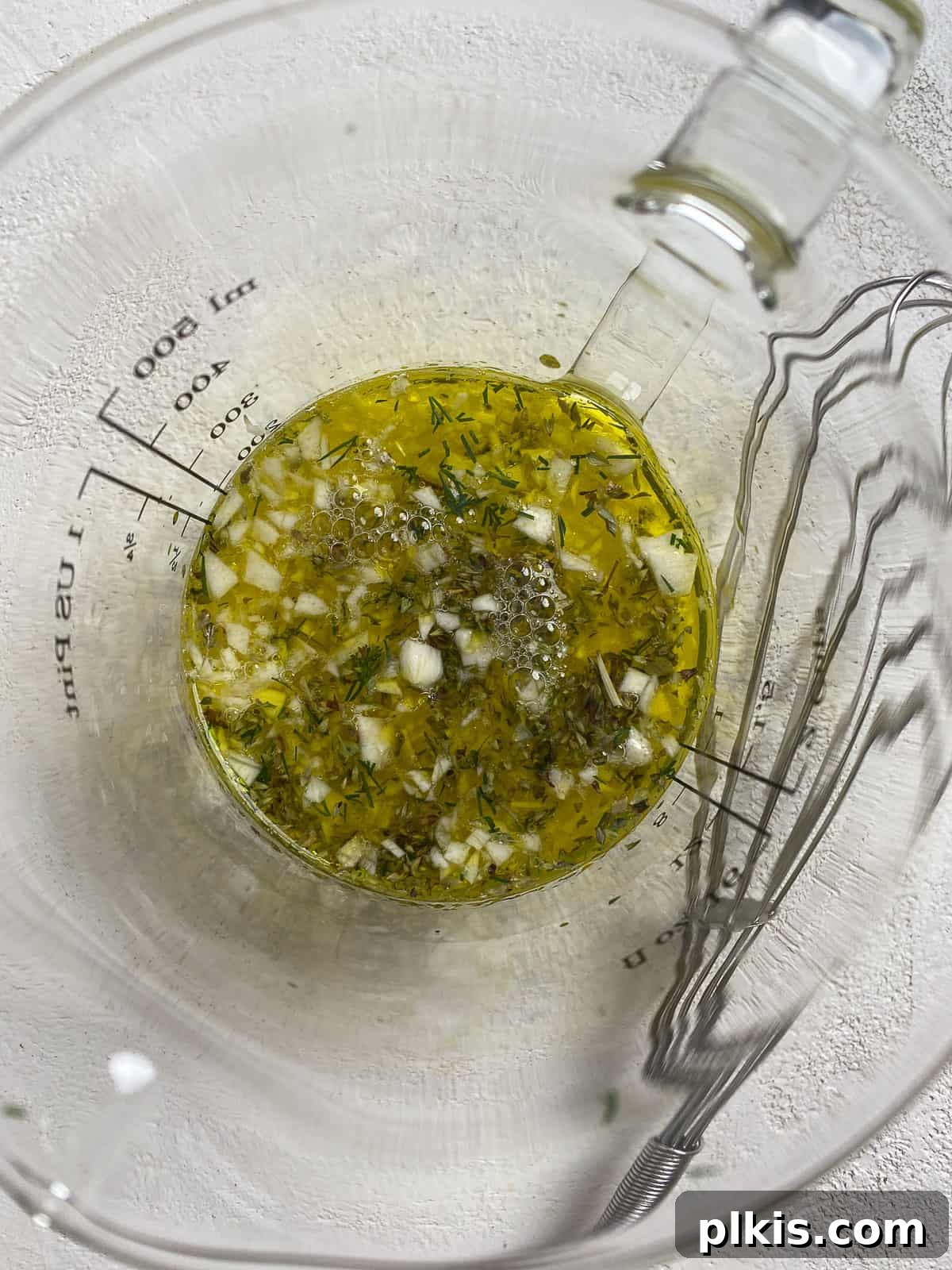 Process of mixing wet ingredients in a measuring cup for the farro and roasted vegetables recipe