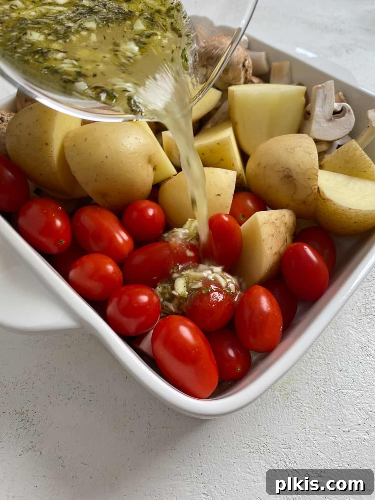 Process of adding seasonings and dressing to a dish with mixed vegetables before roasting for the farro recipe