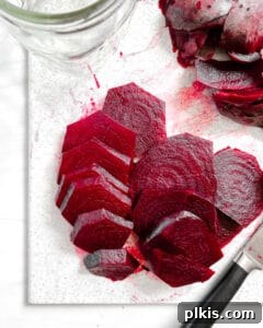 Sliced beets arranged against a white background, ready for jarring.
