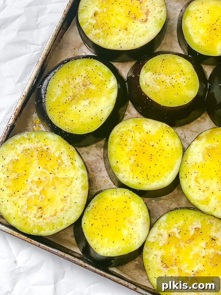 Effortless Eggplant Curry 4 Sliced eggplant rounds on a baking tray, ready for roasting