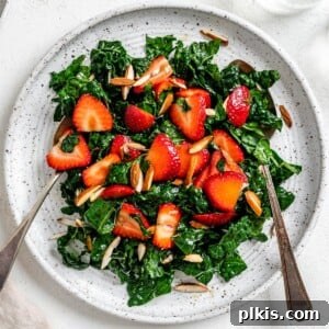 Berry Burst Kale Salad 11 completed Strawberry Kale Salad on a white plate against a white surface