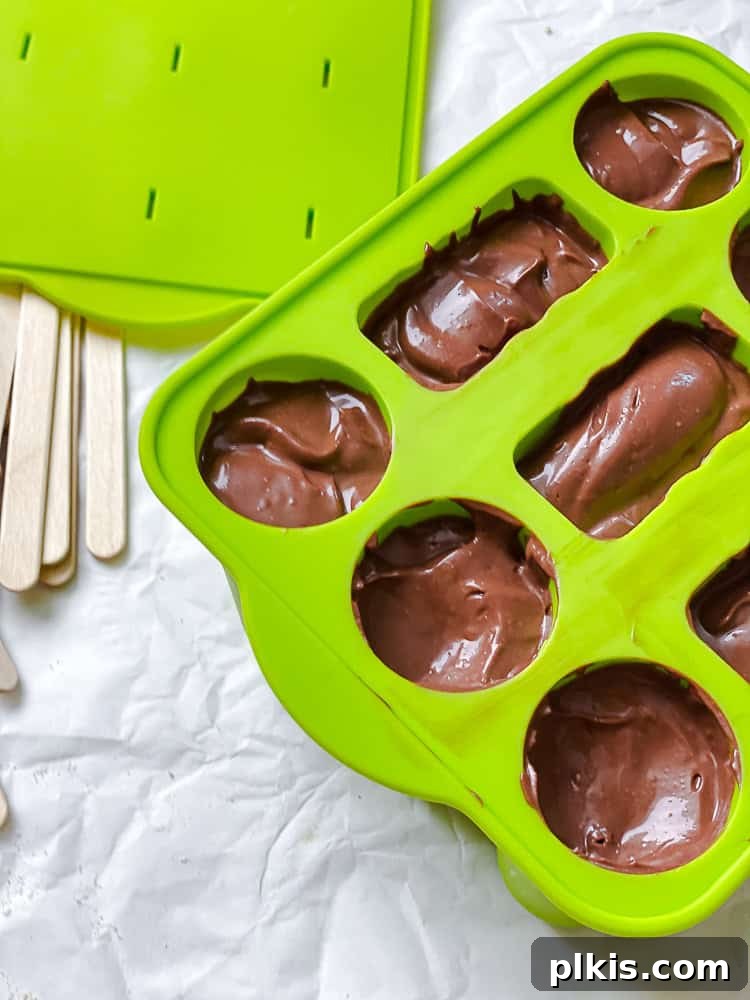 Protein-Packed Chocolate Peanut Butter Pops 6 Pouring the chocolate peanut butter mixture into popsicle molds