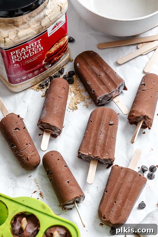 Protein-Packed Chocolate Peanut Butter Pops 7 A cluster of completed Chocolate Peanut Butter Protein Popsicles on a white surface, ready to be enjoyed