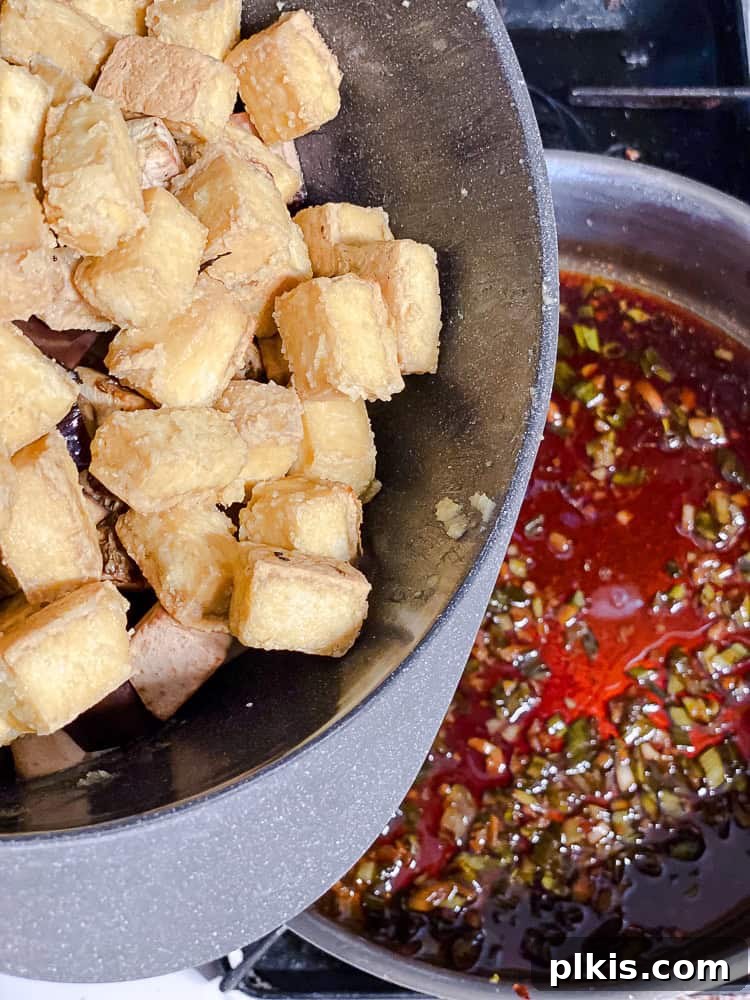 Sweet Chili Glazed Eggplant and Tofu 8 A process shot showing baked crispy tofu being added to a pan with the aromatic ginger, garlic, and green onion mixture.