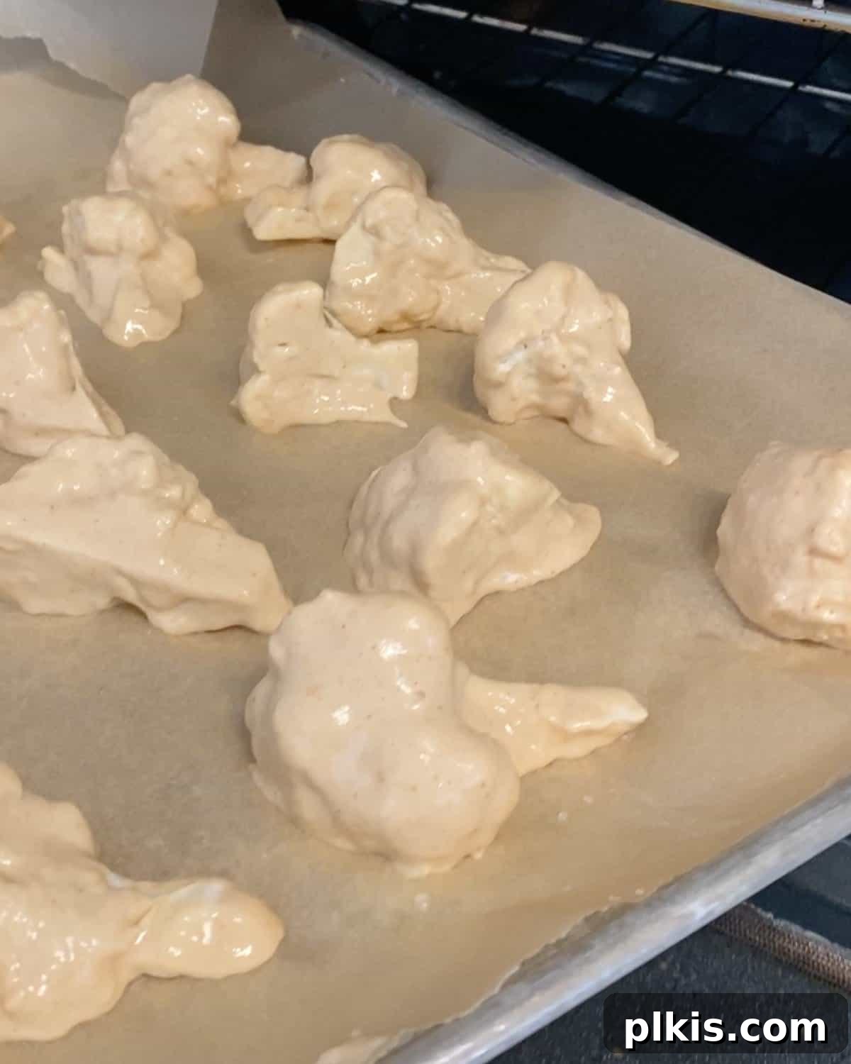 Process shot showing cauliflower with batter on parchment paper