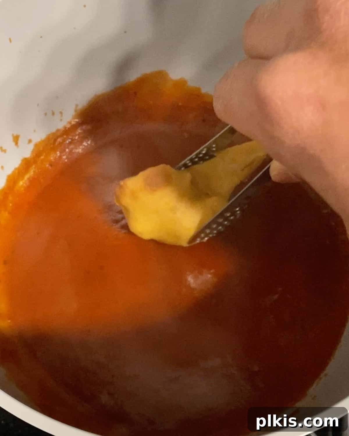 Process shot of dipping cauliflower with batter into bbq sauce