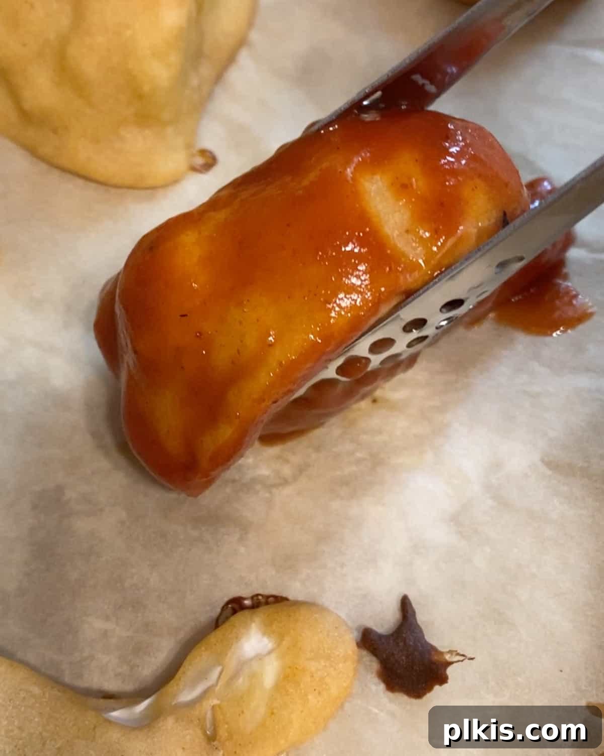 Process shot of placing bbq cauliflower wings onto parchment paper