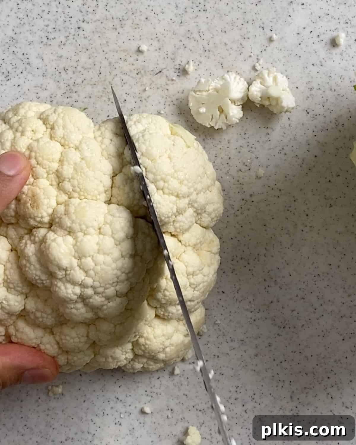 Process shot of cutting cauliflower against a light surface