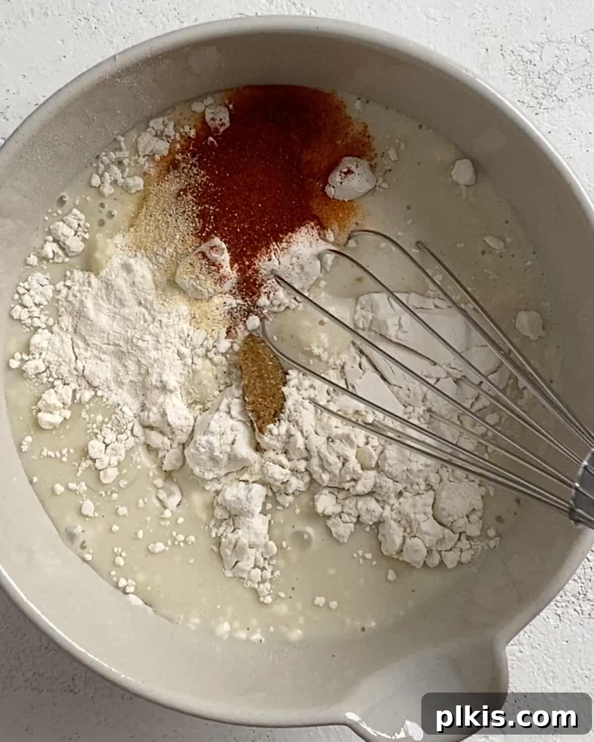 Process shot of mixing ingredients to cauliflower batter