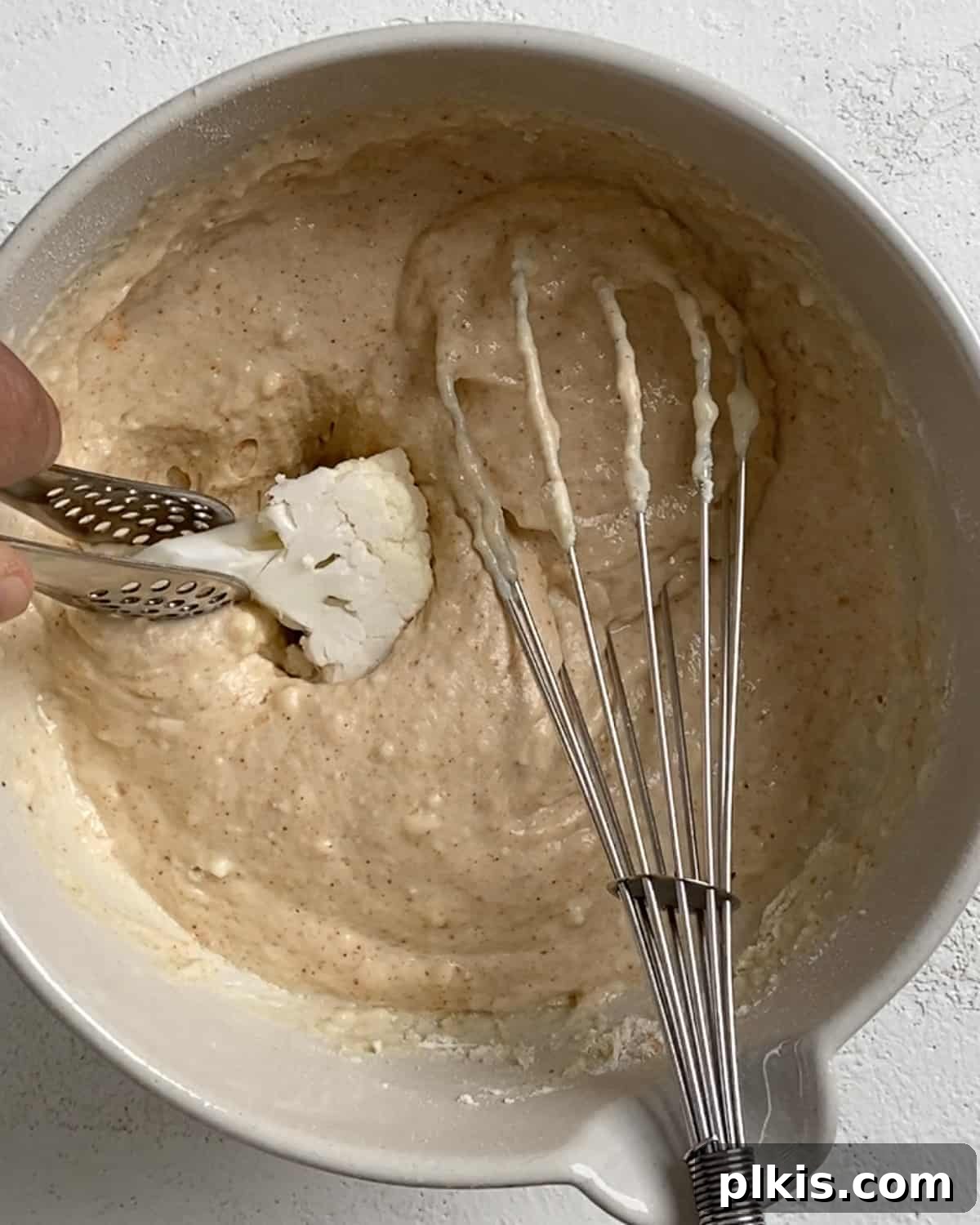 Process shot of mixing ingredients to cauliflower batter with mixer