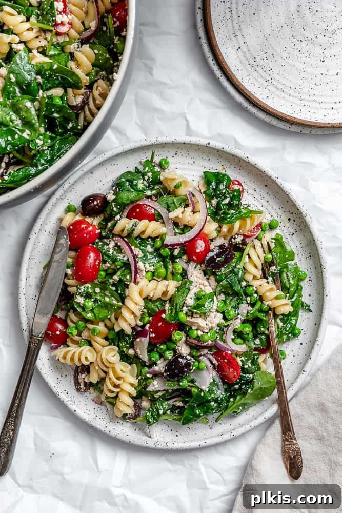 Spinach Pasta Salad on a white plate, ready to be served.
