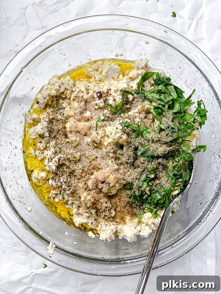 using a spoon to stir the ingredients for tofu feta together.
