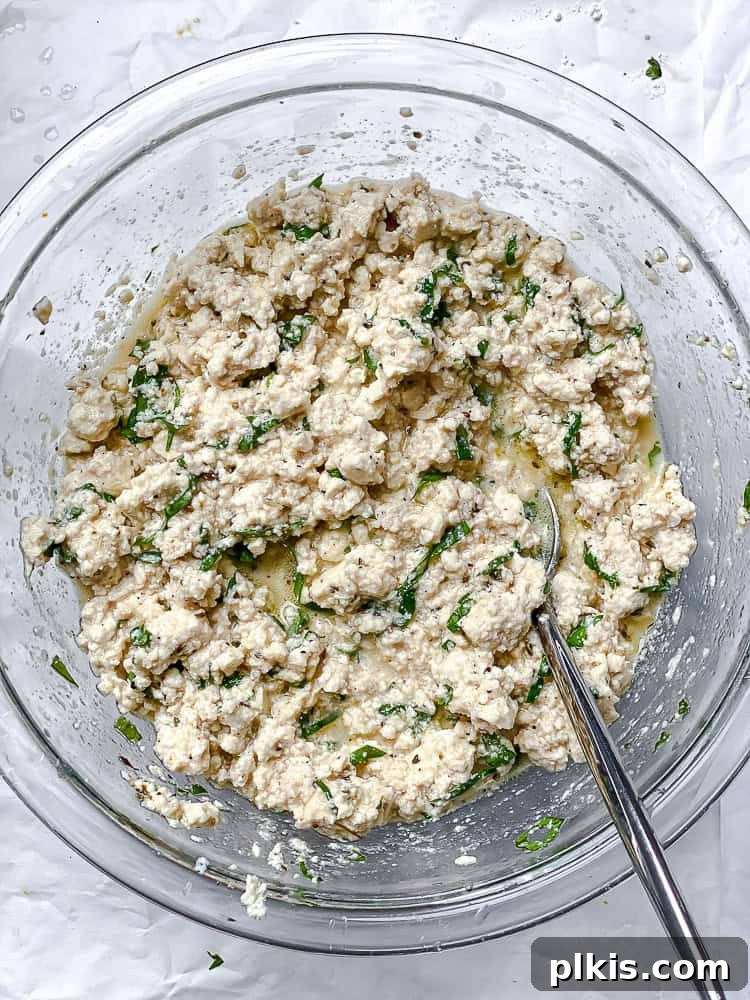 vegan tofu feta stirred together in a large glass bowl.