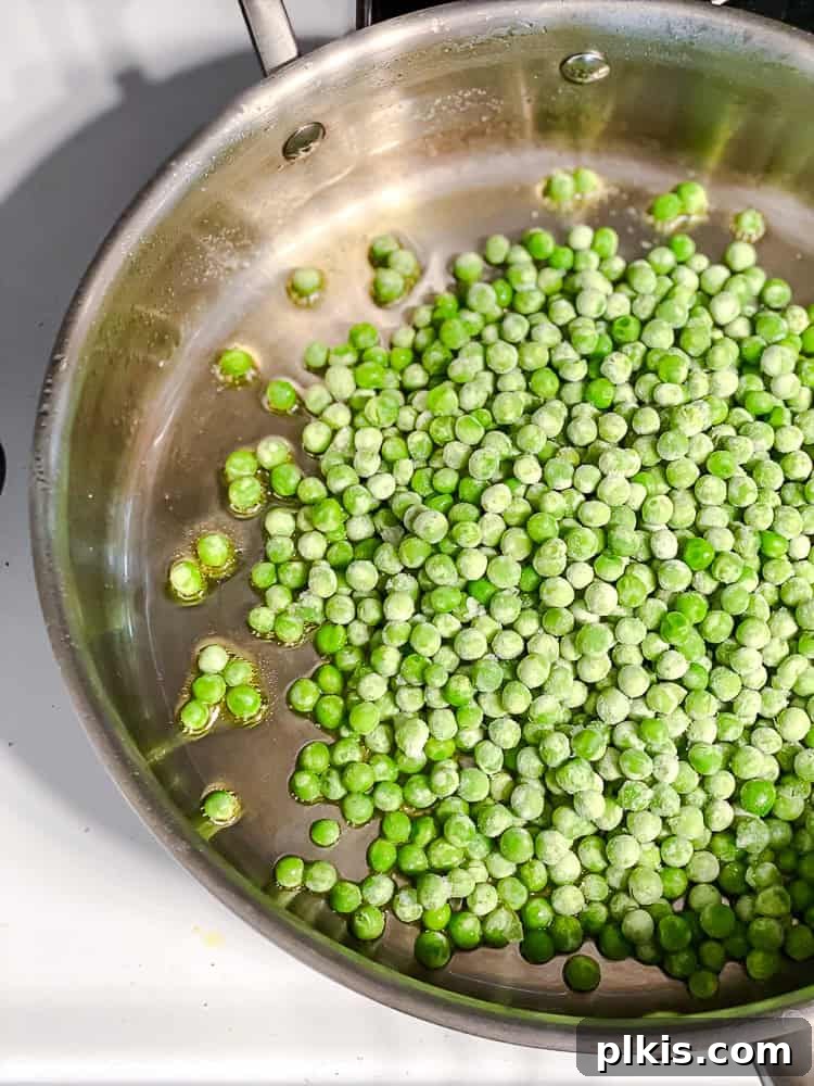 cooking frozen peas in a large frying pan.